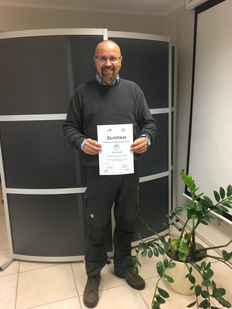 Ein lächelnder Mann mit einem Zertifikat in der Hand
